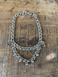 a silver chain bracelet on a wooden table