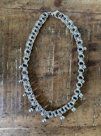 a silver chain bracelet on a wooden table