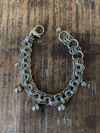 a silver chain bracelet with beads on it